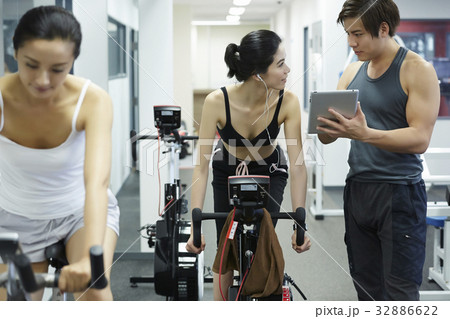 man coach is pointing something for woman at a gym man coach is pointing something for woman at a gym 32886622