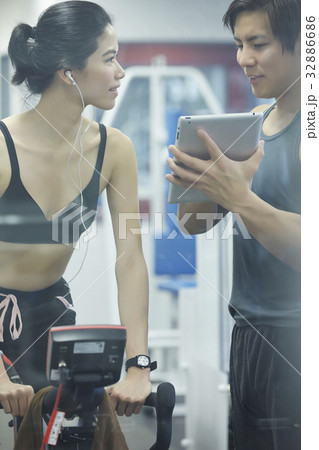 A woman is listening and looking at a man at fitness center 32886686