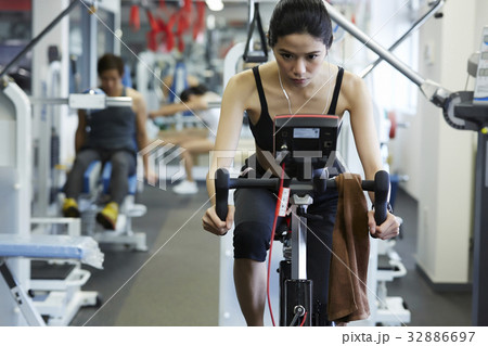 A girl is doing exercise with auto bike at fitness center 32886697
