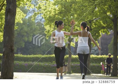 a picture of two women doing high five when running in the morning a picture of two women doing high five when running in the morning 32886759