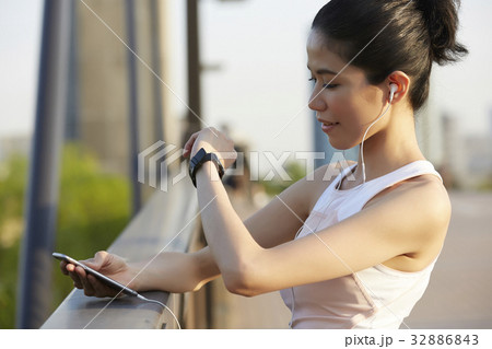 a portrait of a woman standing outside and looking at her watch. a portrait of a woman standing outside and looking at her watch. 32886843