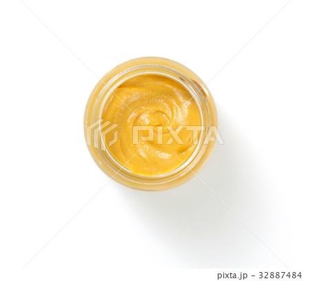 mustard sauce in plate on white background 32887484