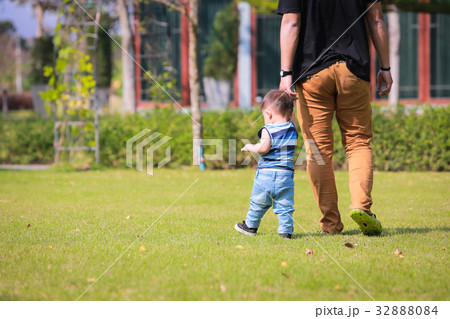 Happy father and little boy walking in summer park Happy father and little boy walking in summer park 32888084