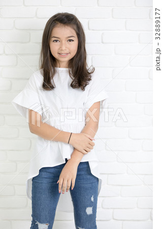 Happy cute girl with blue jeans and smiling looking at camera. Happy cute girl with blue jeans and smiling looking at camera. 32889177