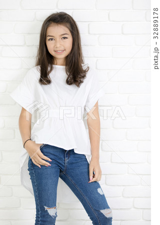 Happy cute girl with blue jeans and smiling looking at camera. Happy cute girl with blue jeans and smiling looking at camera. 32889178