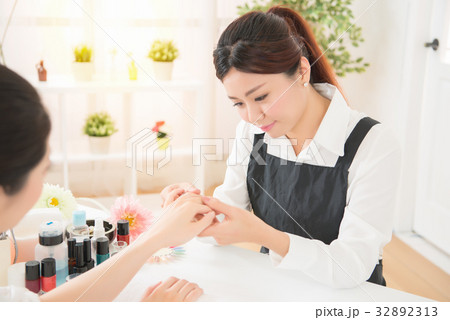 women manicurist checking nail care 32892313