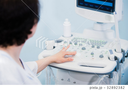 Happy mature female doctor using ultrasound Happy mature female doctor using ultrasound 32892382