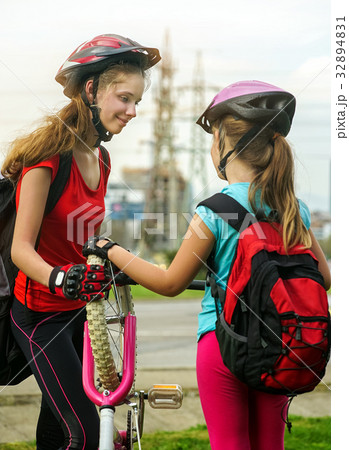 Girls children cycling pump up bicycle tire. Girls children cycling pump up bicycle tire. 32894831