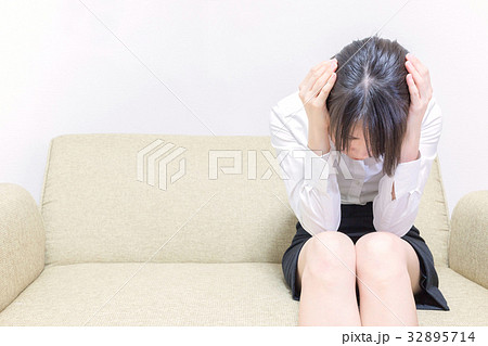 頭を抱え込む女性の写真素材