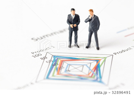 Miniature model of businessman standing on chart Miniature model of businessman standing on chart 32896491