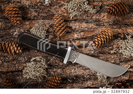 Black decorative knife on a tree bark Black decorative knife on a tree bark 32897932