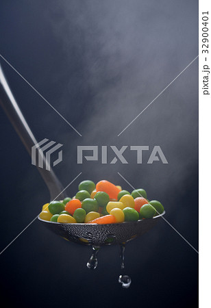 Boiled green peas, corn and carrot in a ladle with 32900401