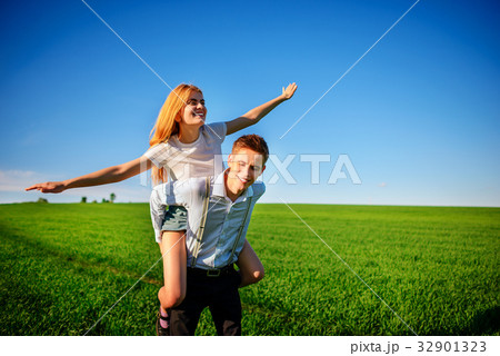 Smiling Man is holding on his back happy woman 32901323
