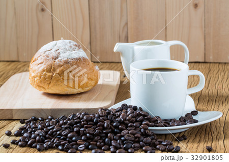 Coffee cup and sourdough roll on wooden table 32901805