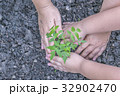 Two hands of a woman and a boy planting trees 32902470