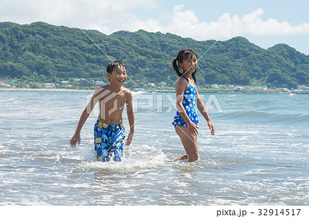 海で遊ぶ水着の小学生 夏休みの写真素材