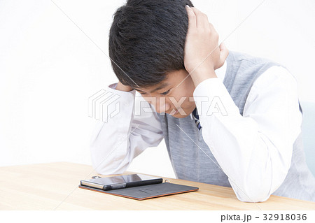 ネットトラブルに悩む学生男の子 32918036