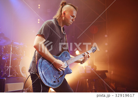 Guitarist performing on stage. Concert. 32919617