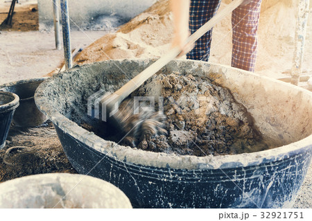 A worker is mixing cement in construction site 32921751
