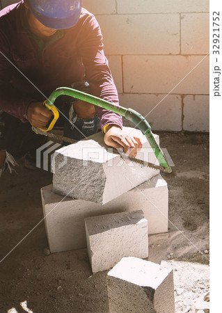 construction worker using saw for cutting bricks construction worker using saw for cutting bricks 32921752