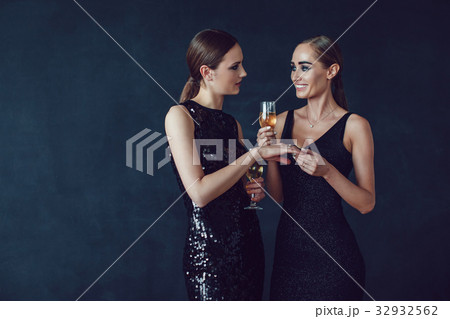 Attractive women in cocktail dresses are holding 32932562
