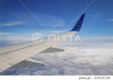 Airplane wing on the sky and over sea with clouds 32933146