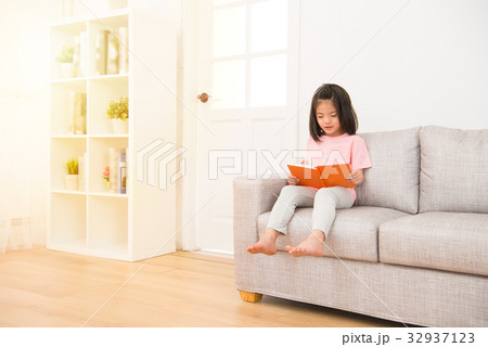 girl sitting in the living room on the couch girl sitting in the living room on the couch 32937123