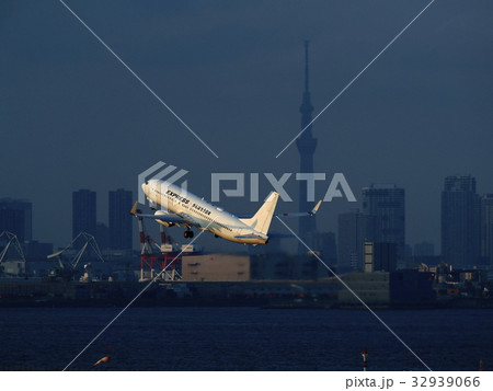 羽田空港を離陸する旅客機と東京スカイツリーの写真素材