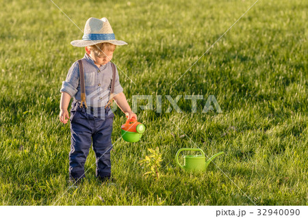 One year old baby boy using watering can One year old baby boy using watering can 32940090