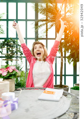 Cheerful florist with arms raised 32942049