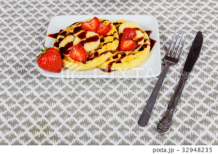 Homemade waffles with berries in plate on table Homemade waffles with berries in plate on table 32948235