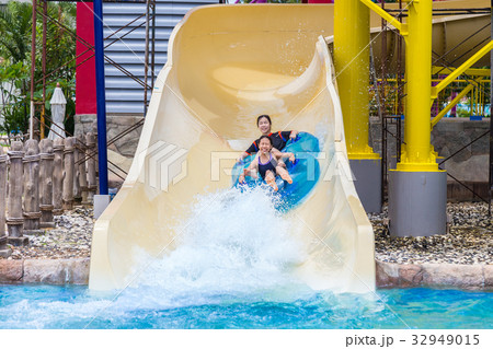 asian teenagers enjoying their water slider ride 32949015