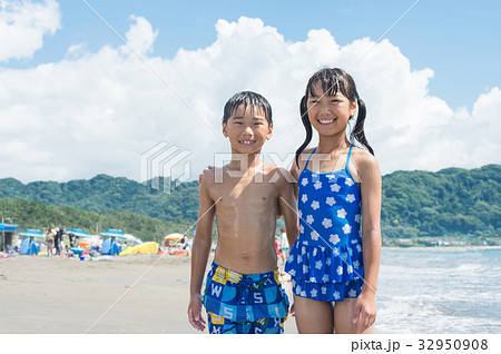 海水浴 水着の小学生 夏休みの写真素材