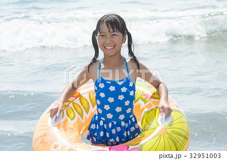 水着の女の子 海と浮き輪の写真素材