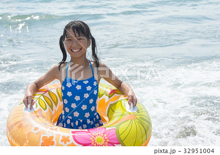 水着の女の子 海と浮き輪の写真素材