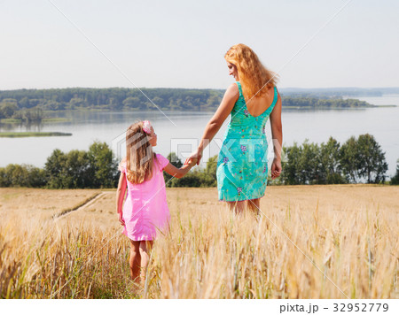 Mother and daughter walking  in summer field 32952779