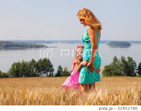 little girl hugging her mother in a wheat field little girl hugging her mother in a wheat field 32952780