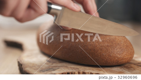 young female hands slicing rye wheat rustic bread young female hands slicing rye wheat rustic bread 32960696