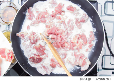 Chef stiring slice of beef with coconut milk Chef stiring slice of beef with coconut milk 32960701