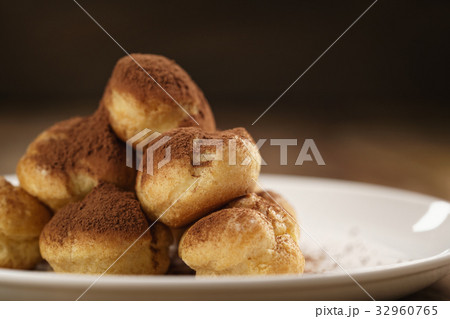 closeup shot of profiteroles covered with cocoa closeup shot of profiteroles covered with cocoa 32960765