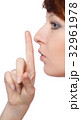 a girl holds a finger to lips gesture silently 32961978