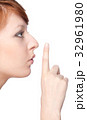 a girl holds a finger to lips gesture silently 32961980