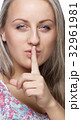 a girl holds a finger to lips gesture silently 32961981
