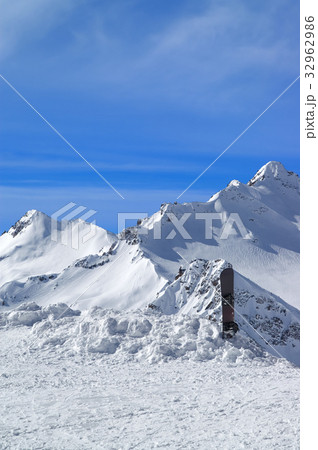 Snowboard against the snowy mountains Snowboard against the snowy mountains 32962986