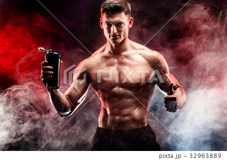 Muscular man with protein drink in shaker 32963889