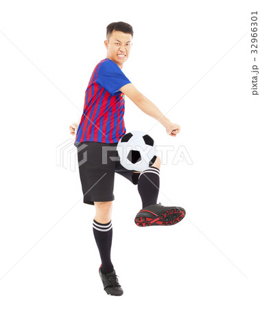 Young soccer player kicking ball 32966301
