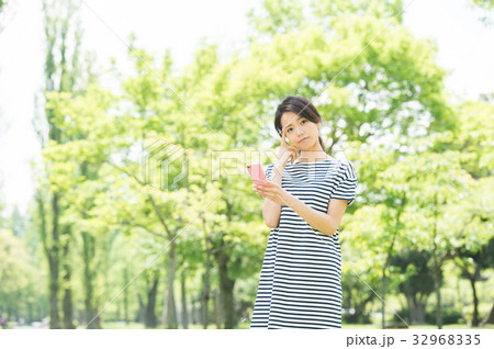 携帯電話を持つ女性（緑背景） 32968335