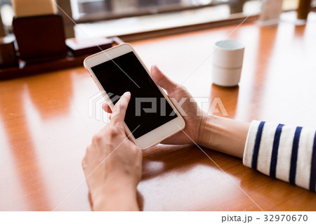 Woman using cellphone at restaurant 32970670