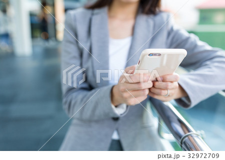 Businesswoman using mobile phone at outdoor Businesswoman using mobile phone at outdoor 32972709