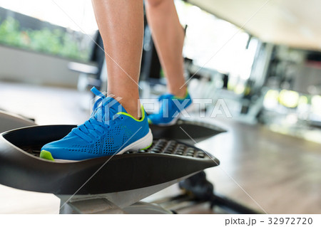 Sport woman working out on elliptical trainer in gym 32972720